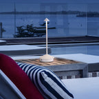 Lampe sans fil Solo blanche sur une table de terrasse face à la mer