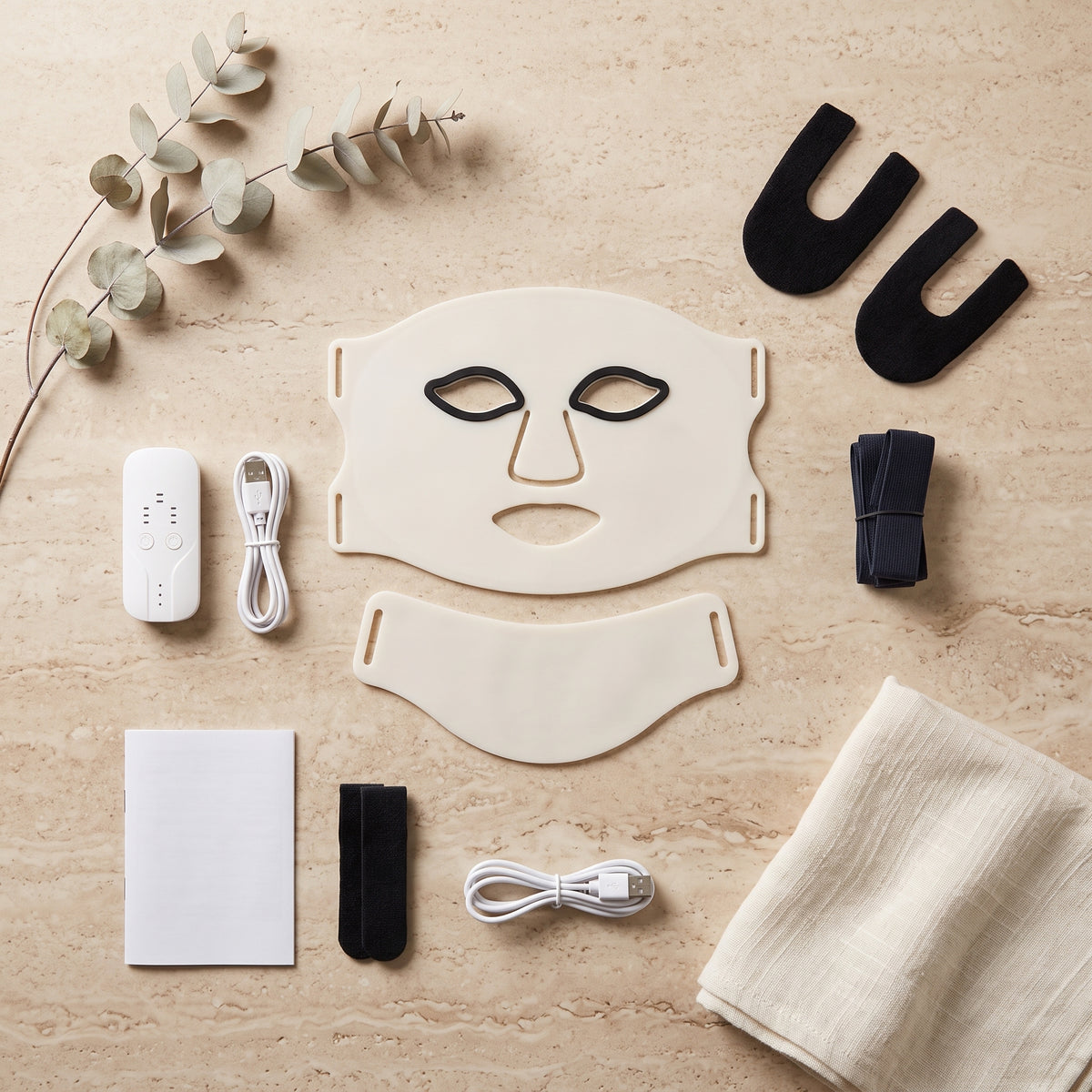 Masque LED Aurore ivoire et ses accessoires sur travertin