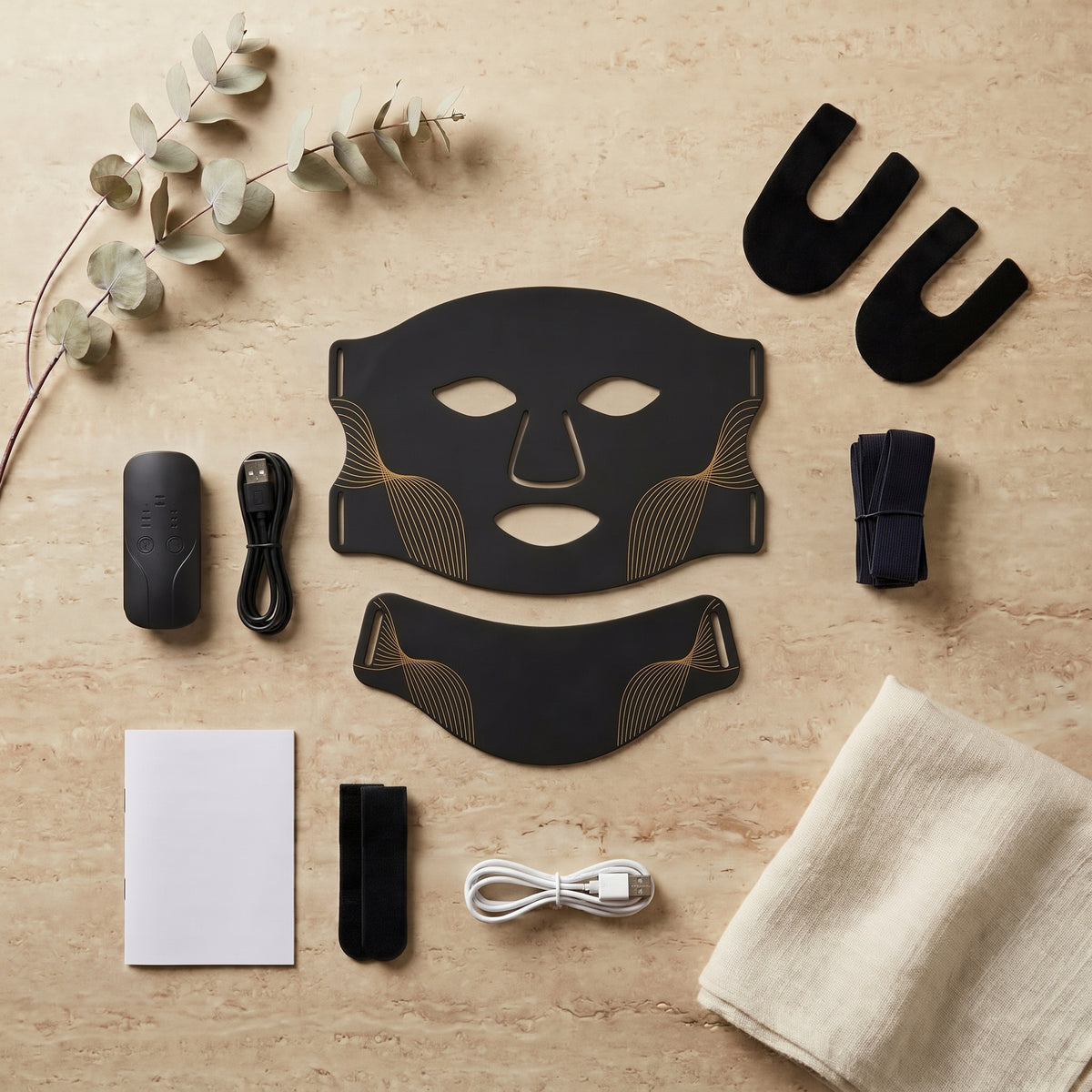 Masque LED Aurore noir et ses accessoires sur travertin