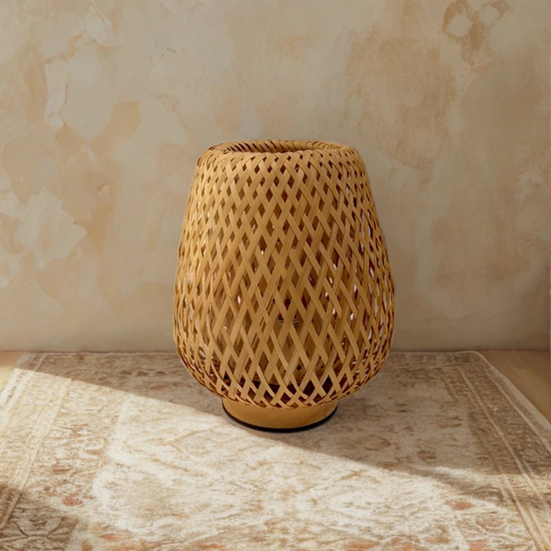 Lampe en bambou tressé Bourrée posée sur un tapis