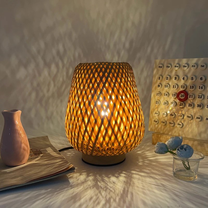Lampe en bambou Bourrée allumée, losanges de lumière projetés sur le mur