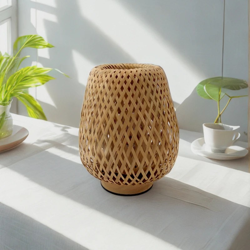 Lampe Bourrée en bambou à côté d'une plante, en journée
