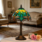 Lampe Tiffany Gavotte allumée dans un salon, vitrail aux libellules vertes