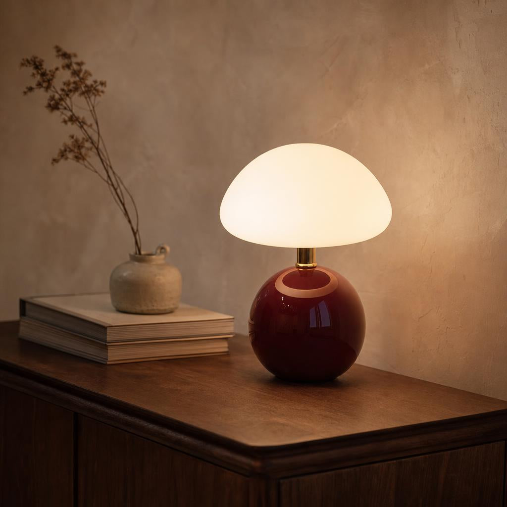 Lampe champignon Romance bordeaux allumée sur un buffet en noyer