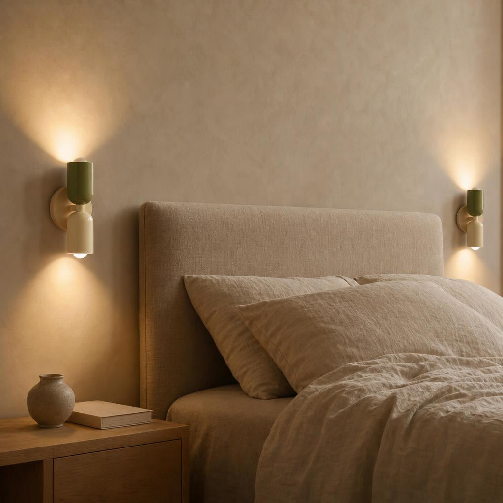 Deux appliques Menuet sauge et crème allumées de chaque côté d'un lit