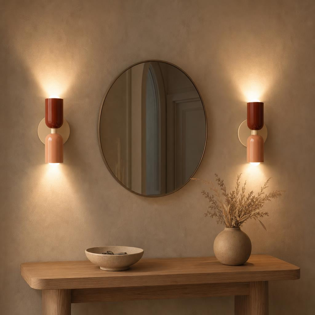 Deux appliques Menuet terracotta et rose autour d'un miroir dans une entrée