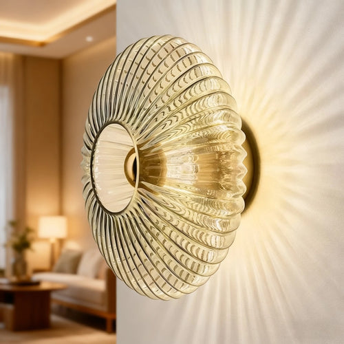 Applique Intermezzo en verre strié fumé allumée dans un salon, rayons de lumière sur le mur