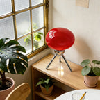 Lampe Bauhaus Scherzo rouge, globe en verre sur trépied chromé, près d'une fenêtre
