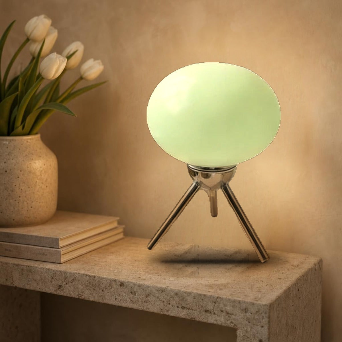 Lampe Bauhaus Scherzo verte allumée sur une console en pierre, globe en verre sur trépied chromé