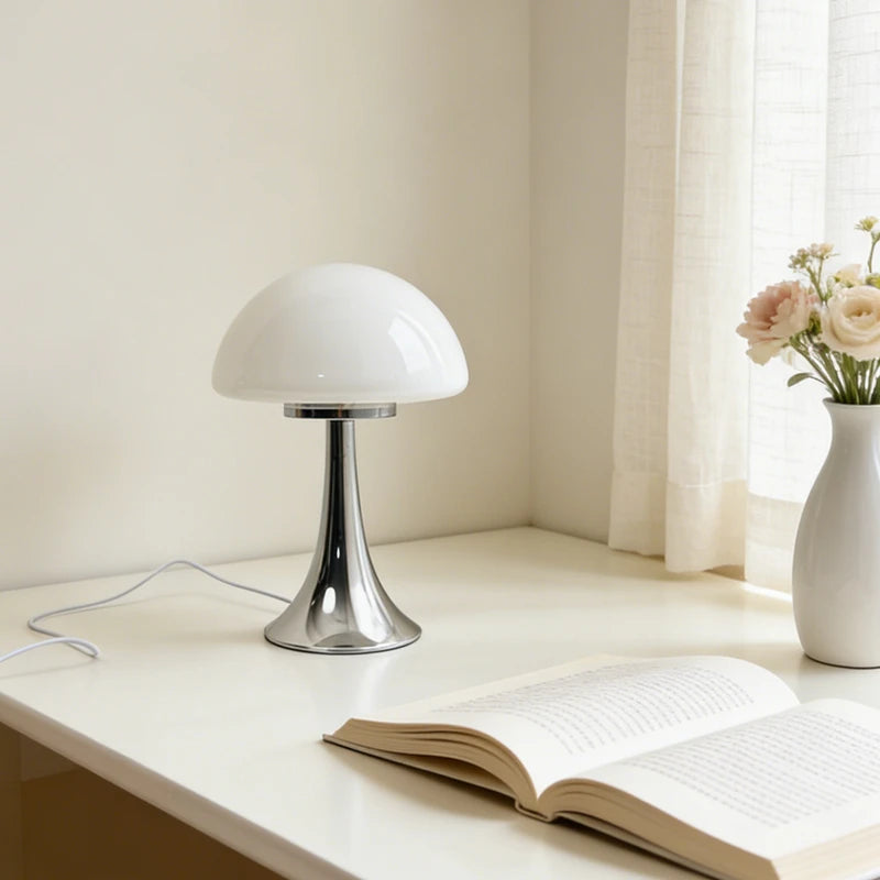 Lampe champignon Polka blanc opalin, pied chromé, sur une table de chevet