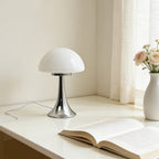 Lampe champignon Polka blanc opalin, pied chromé, sur une table de chevet