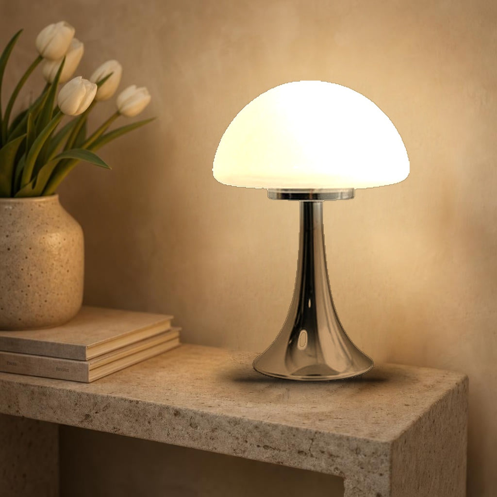 Lampe champignon Polka en verre opalin blanc allumée sur une console en pierre