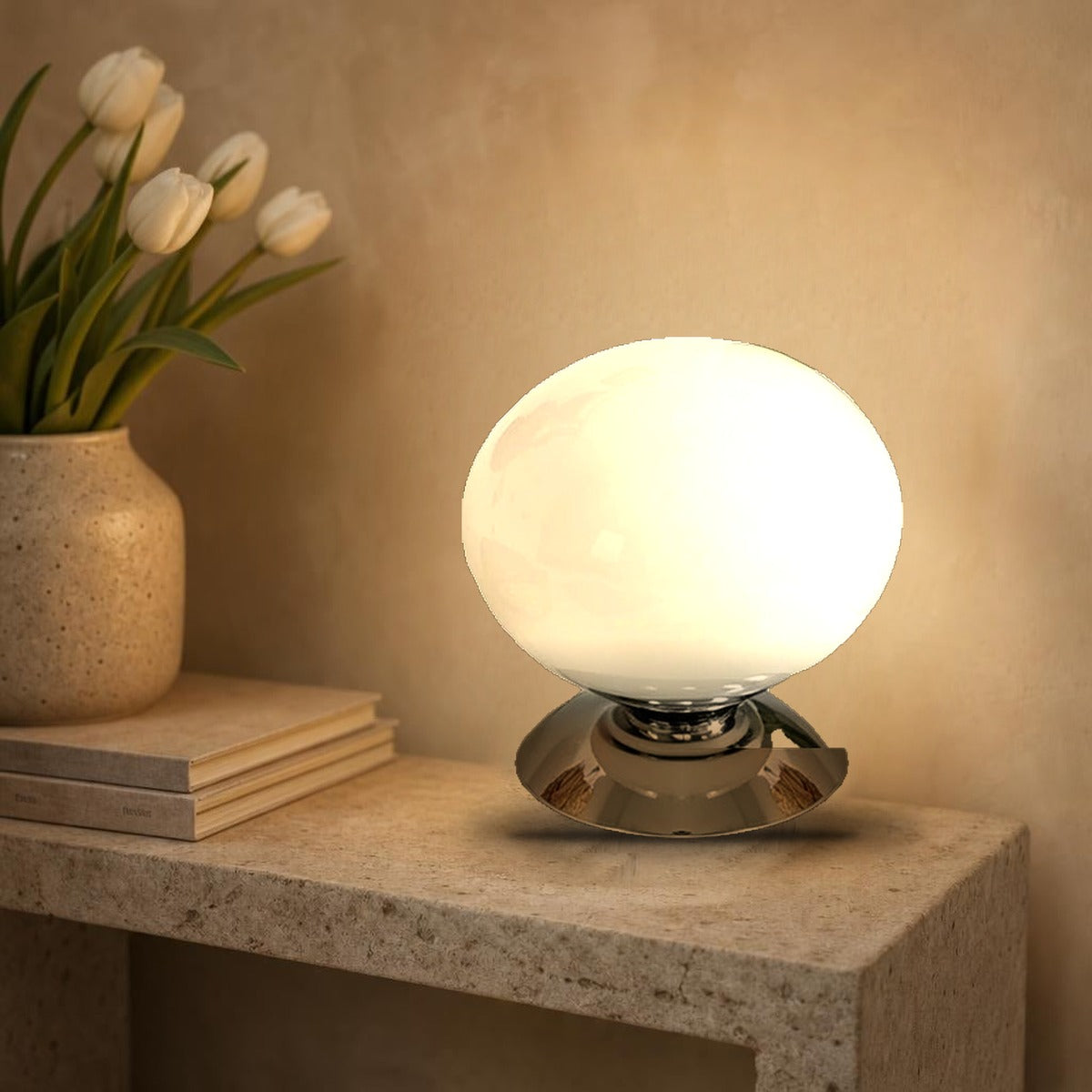 Lampe globe Opus en verre opalin blanc nacré allumée sur une console en pierre