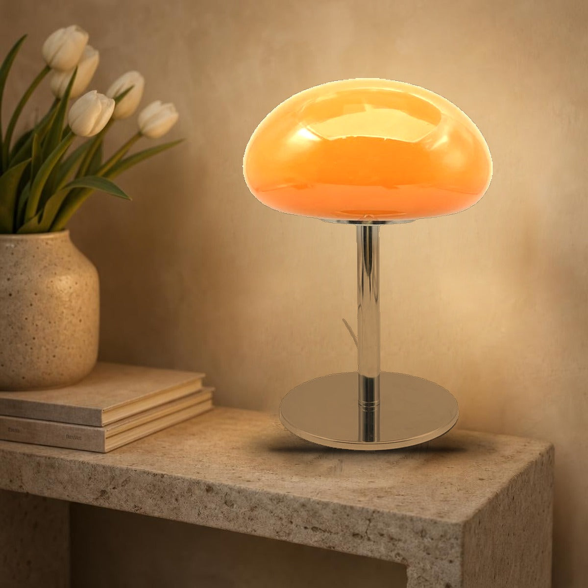 Lampe nuage Mazurka en verre opalin orange allumée sur une console en pierre