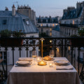 Lampe sans fil Solo dorée sur une table dressée pour deux, balcon parisien au crépuscule