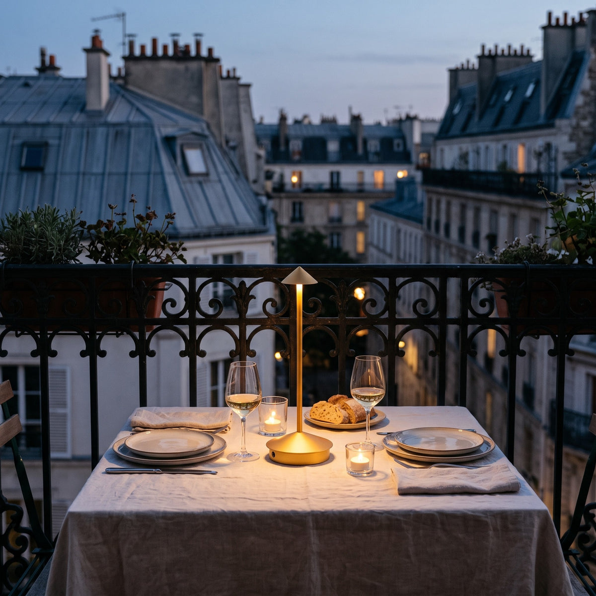 Lampe sans fil Solo dorée sur une table dressée pour deux, balcon parisien au crépuscule