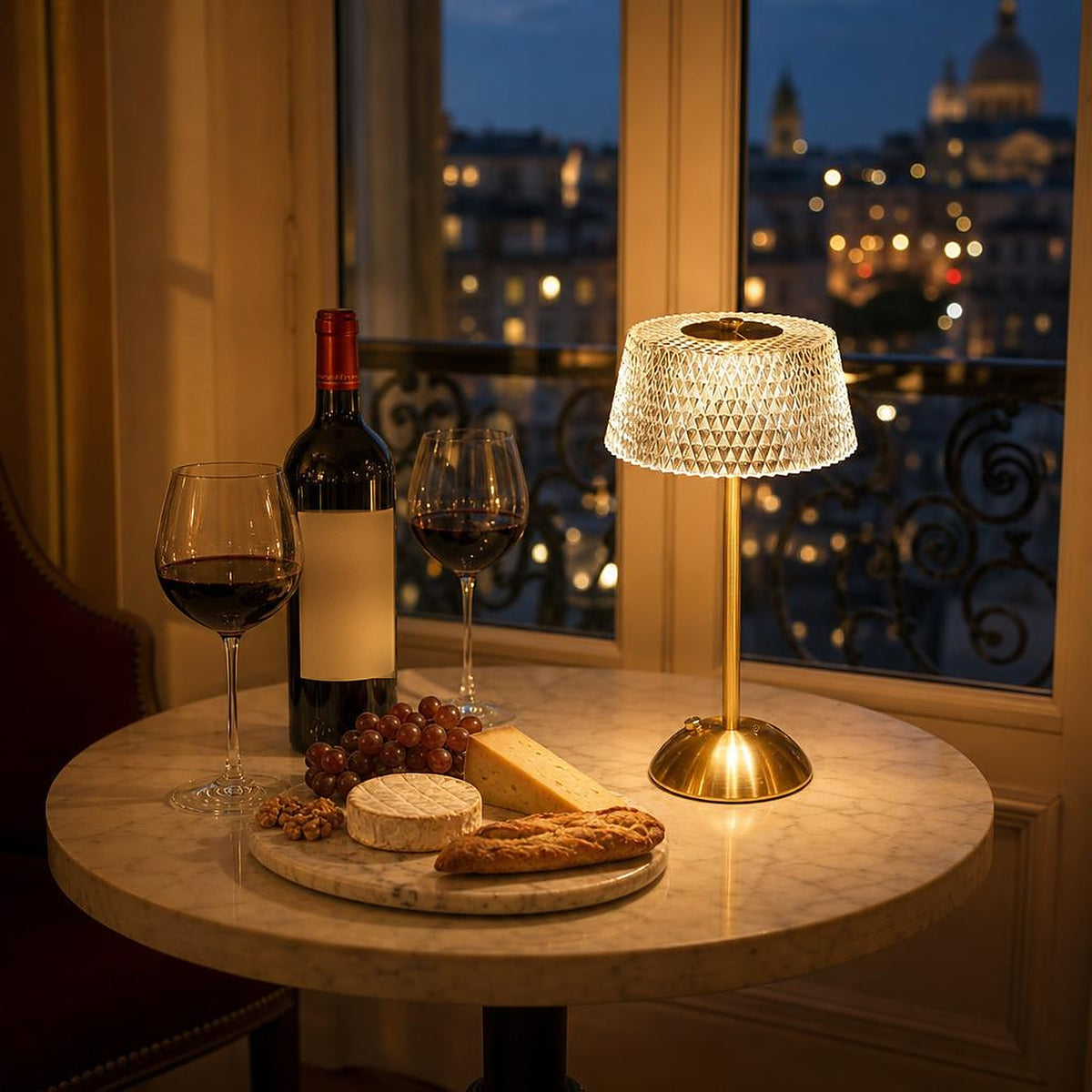 Lampe sans fil Nocturne modèle Coupole sur une table bistrot en marbre, devant une fenêtre sur Paris le soir