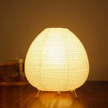Lampe Pavane en papier de riz allumée, lumière chaude et tamisée