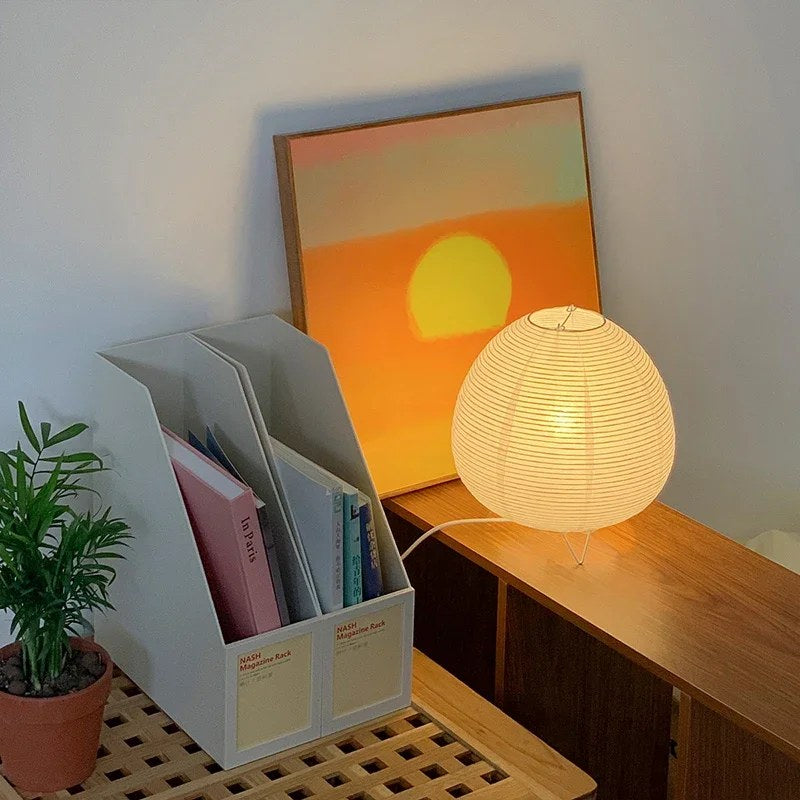 Lampe lanterne Pavane posée sur un bureau, près d'une étagère