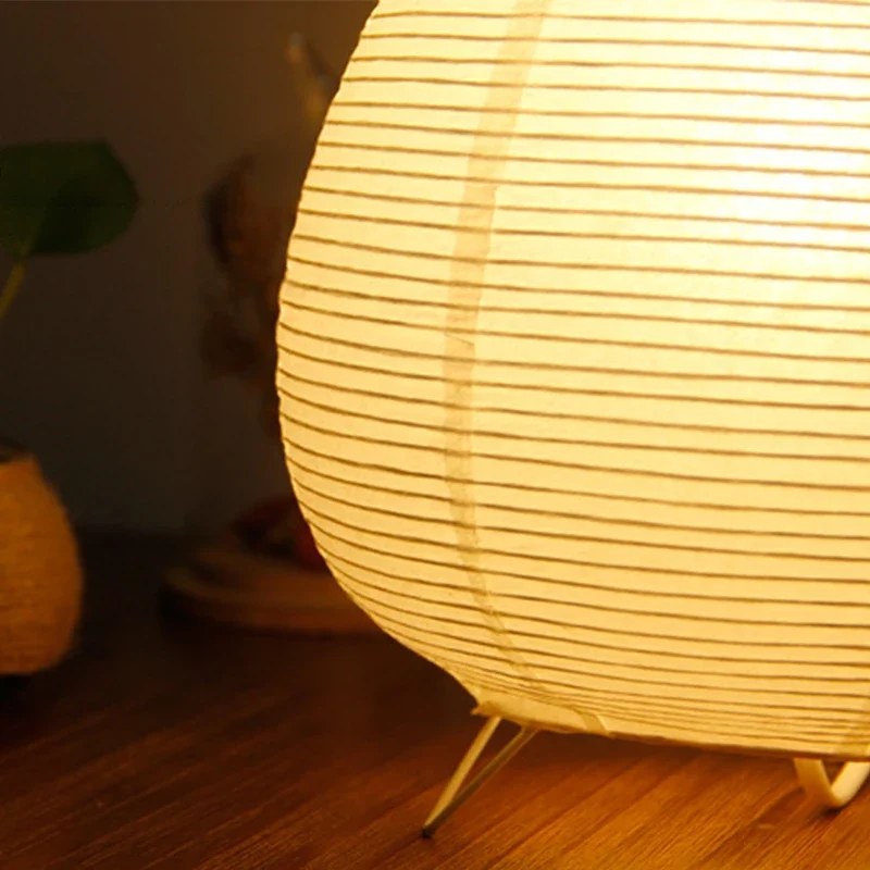 Détail du papier de riz plissé et des pieds en métal de la lampe Pavane