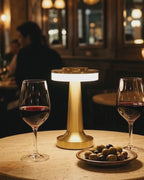 Lampe sans fil Fugue dorée qui s'illumine sur une table de bar à vin